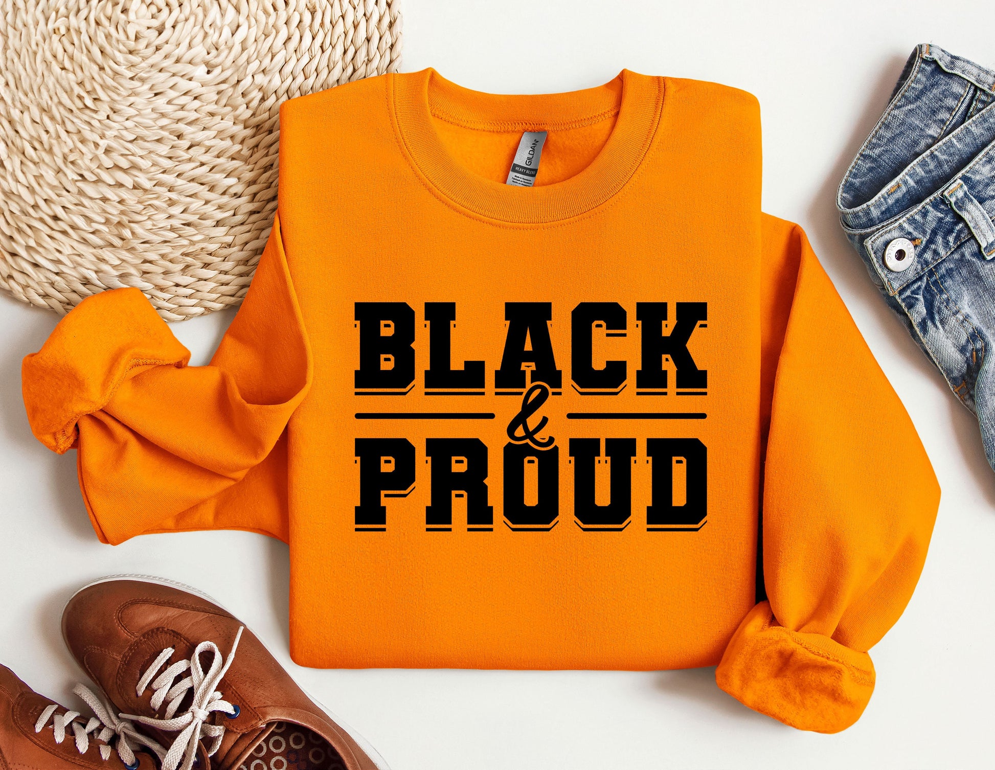 a pair of sneakers and a sweatshirt with the words black and proud on it