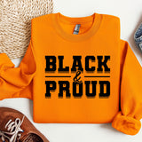 a pair of sneakers and a sweatshirt with the words black and proud on it