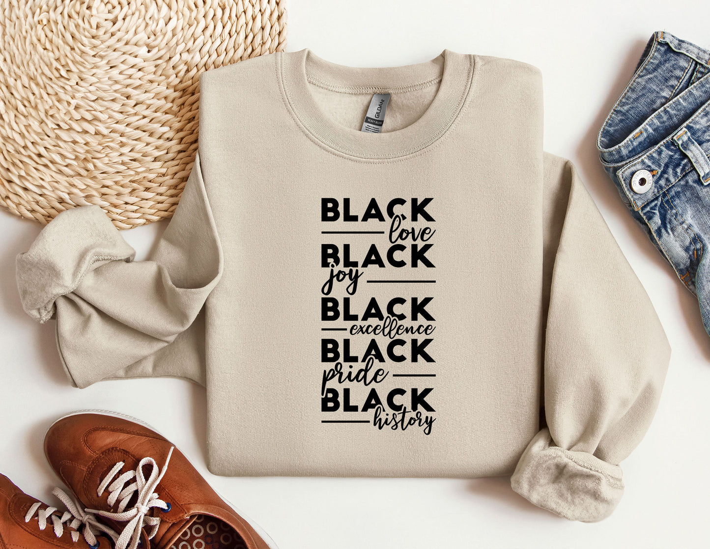 a sweater with black lettering on it next to a pair of shoes