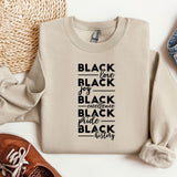 a sweater with black lettering on it next to a pair of shoes