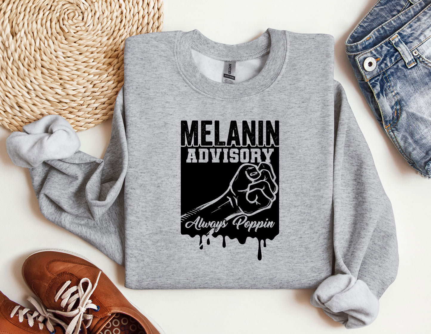 a gray sweatshirt with a black graphic of a fist and the words melanin