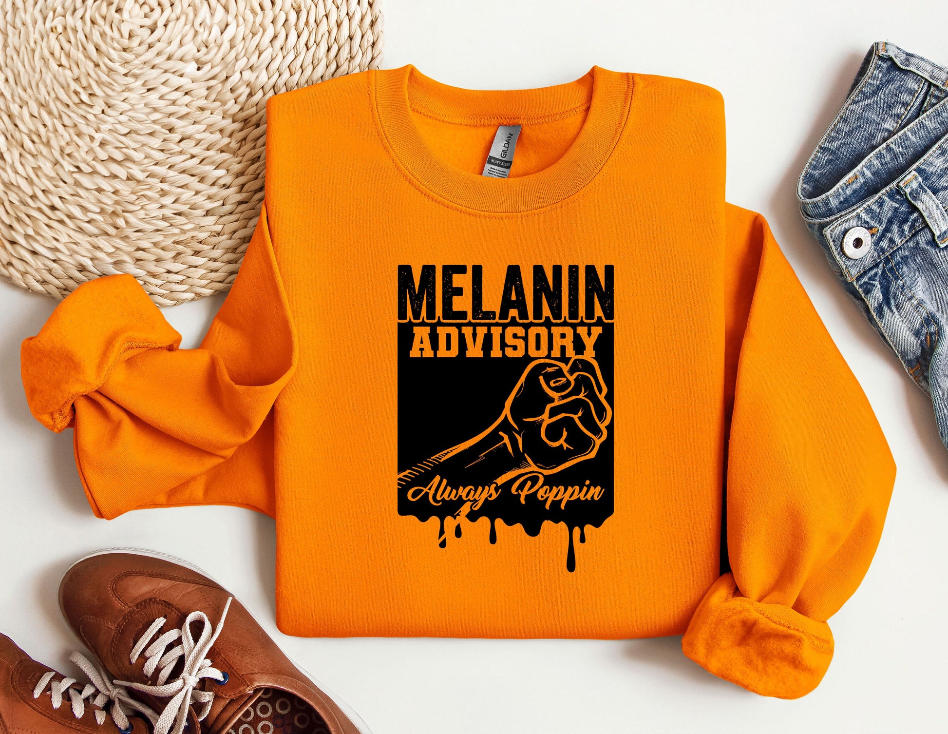 an orange sweatshirt with the slogan melanin advisory on it