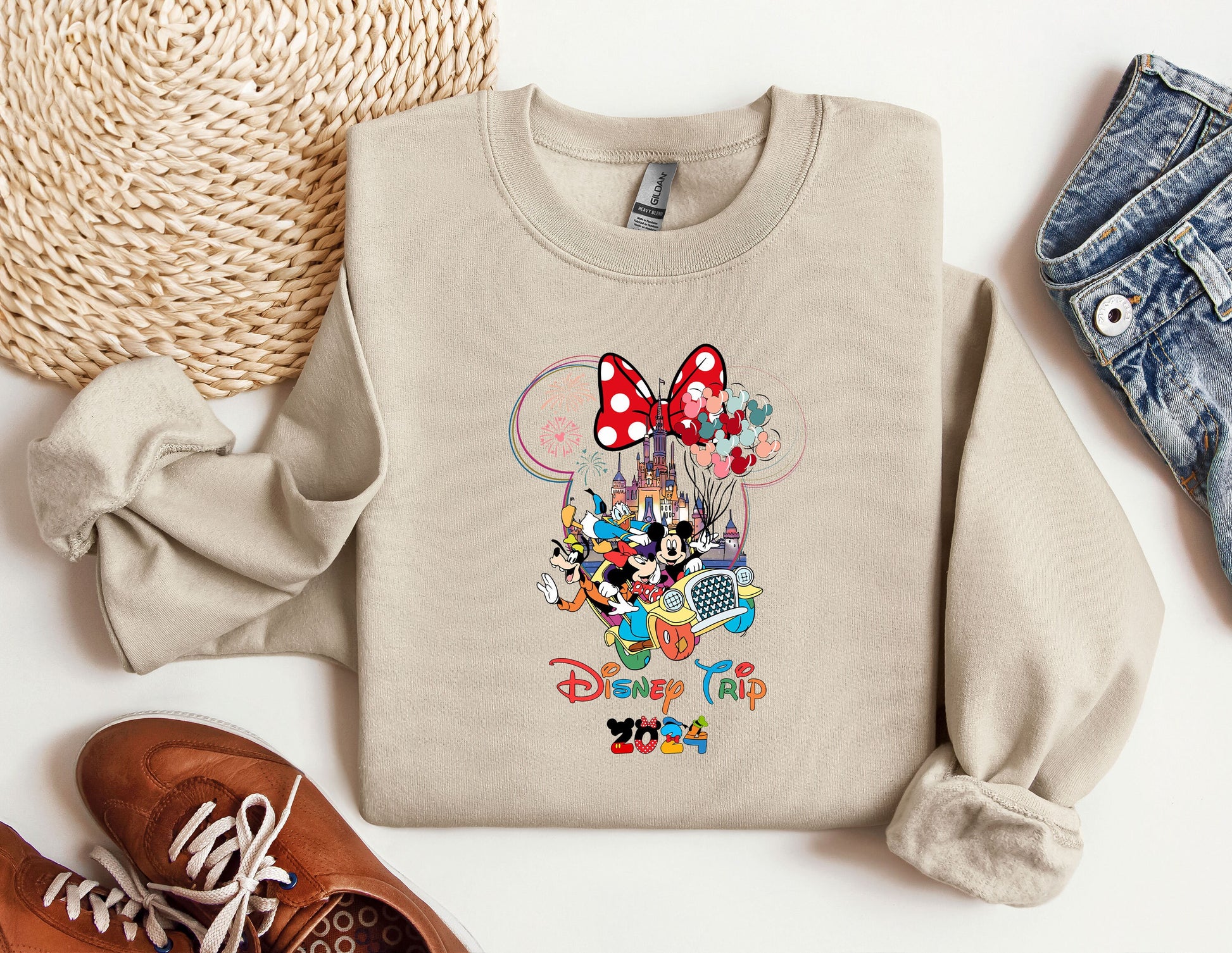 a mickey mouse sweatshirt with a pair of shoes next to it