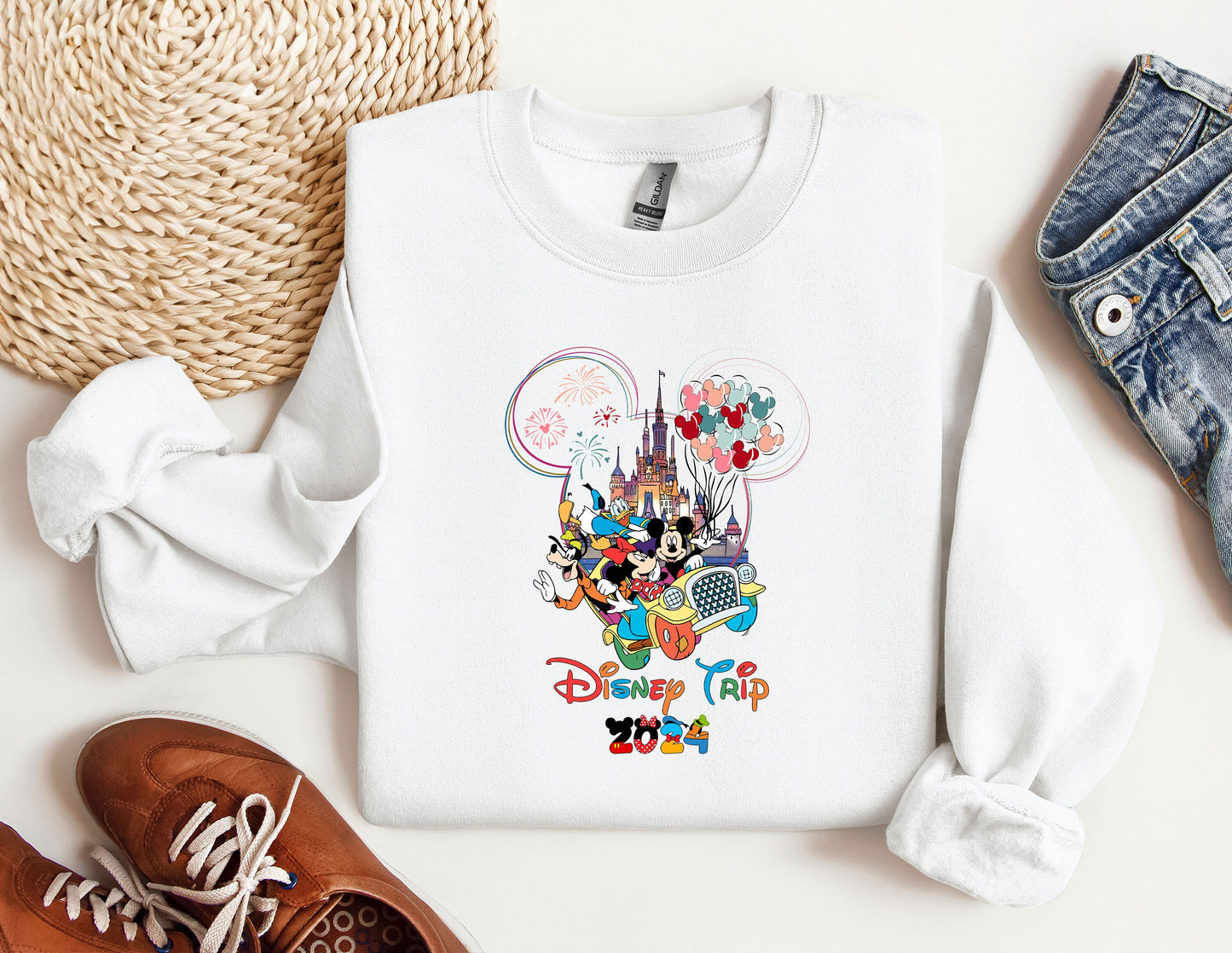 a white shirt with mickey mouse on it next to a pair of shoes