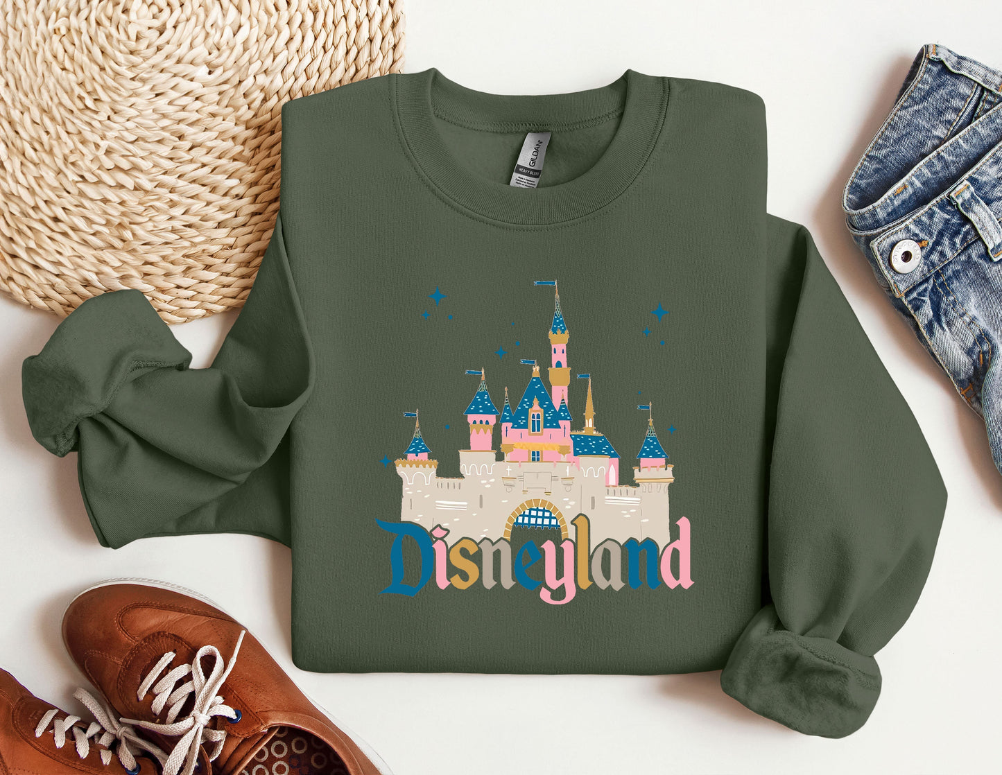 a green sweatshirt with disneyland castle on it