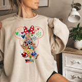 a woman wearing a mickey mouse sweatshirt standing on a bed