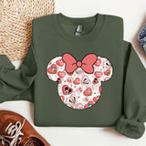 a green sweatshirt with a red bow and hearts on it