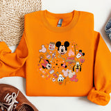 a pair of shoes and an orange shirt with mickey mouse on it