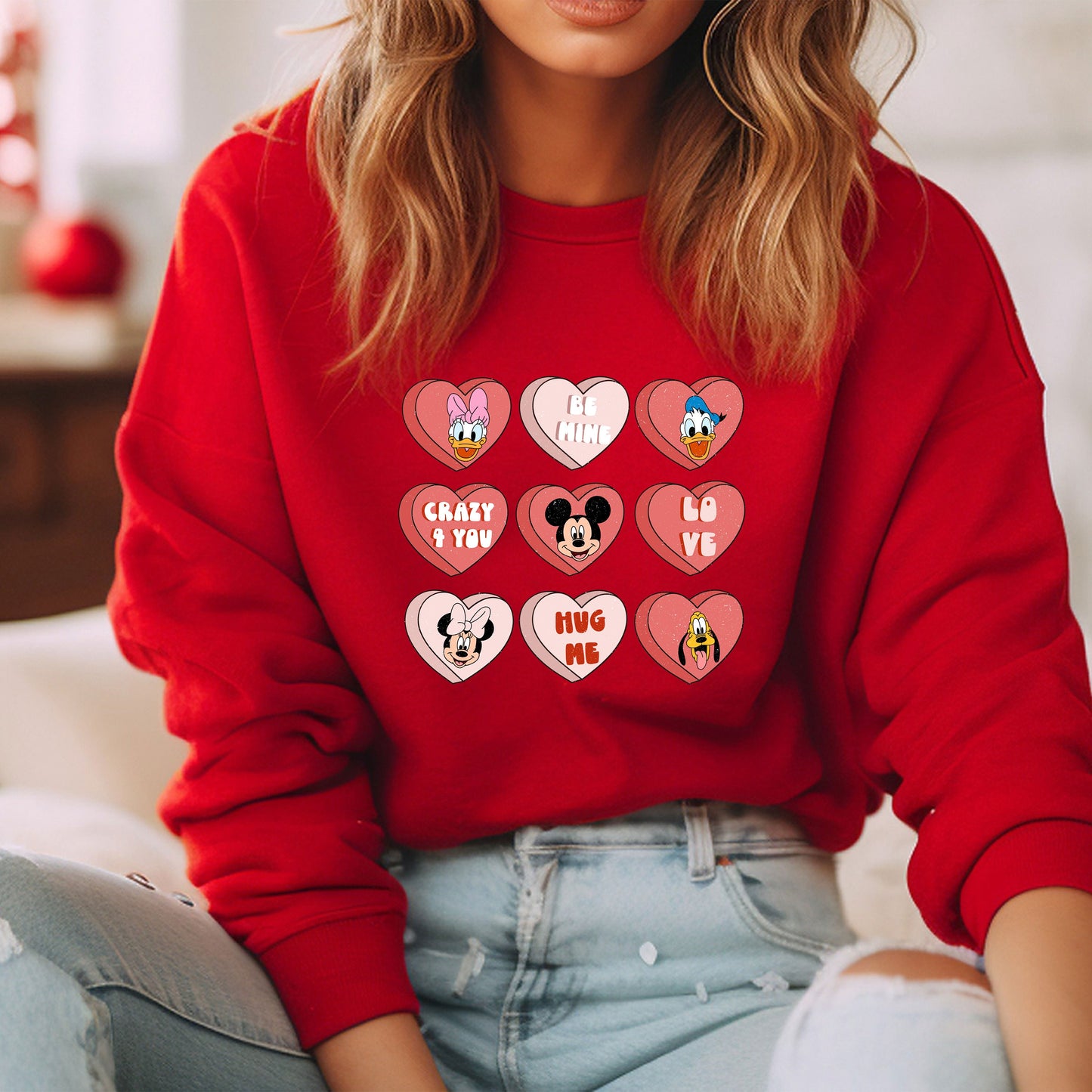 a woman wearing a red sweatshirt with mickey mouse patches on it