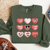 a green sweatshirt with hearts and mickey mouse faces