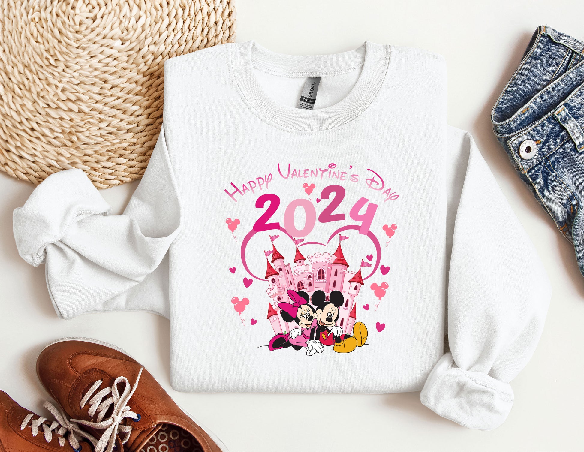 a sweater with a minnie mouse on it next to a pair of shoes