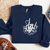 a blue sweatshirt with a skull and flowers on it