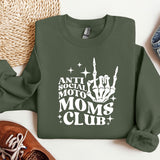 a sweatshirt that says anti social moms club next to a pair of sneakers