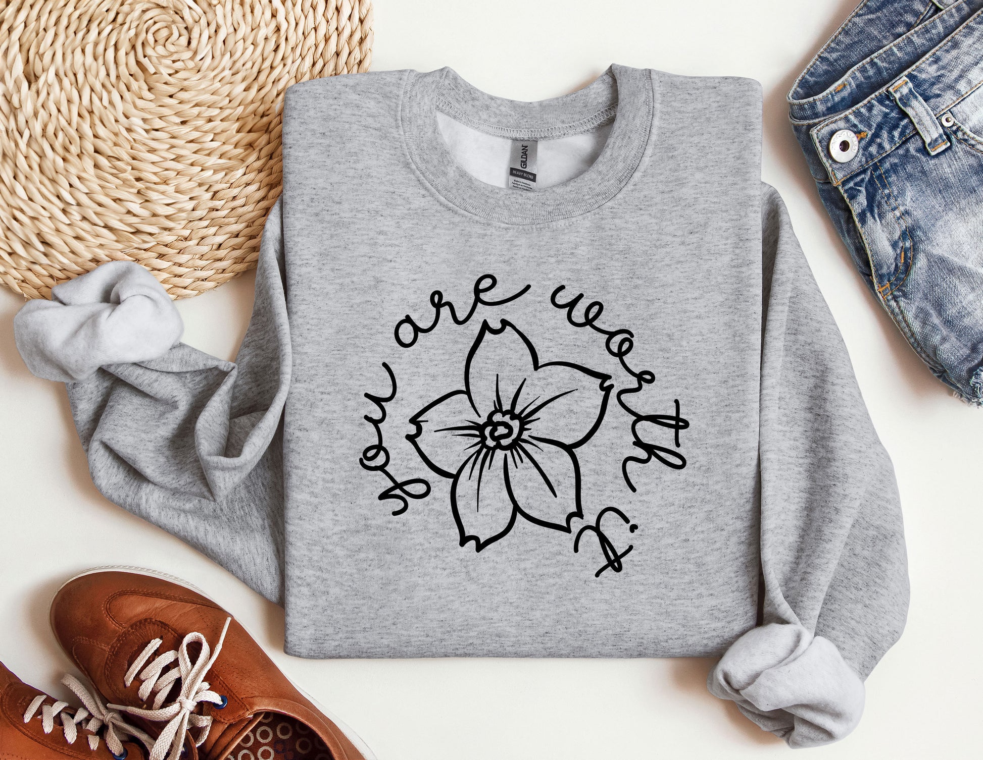 a sweatshirt with a flower on it next to a pair of shoes