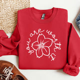 a red shirt with a flower on it next to a pair of shoes