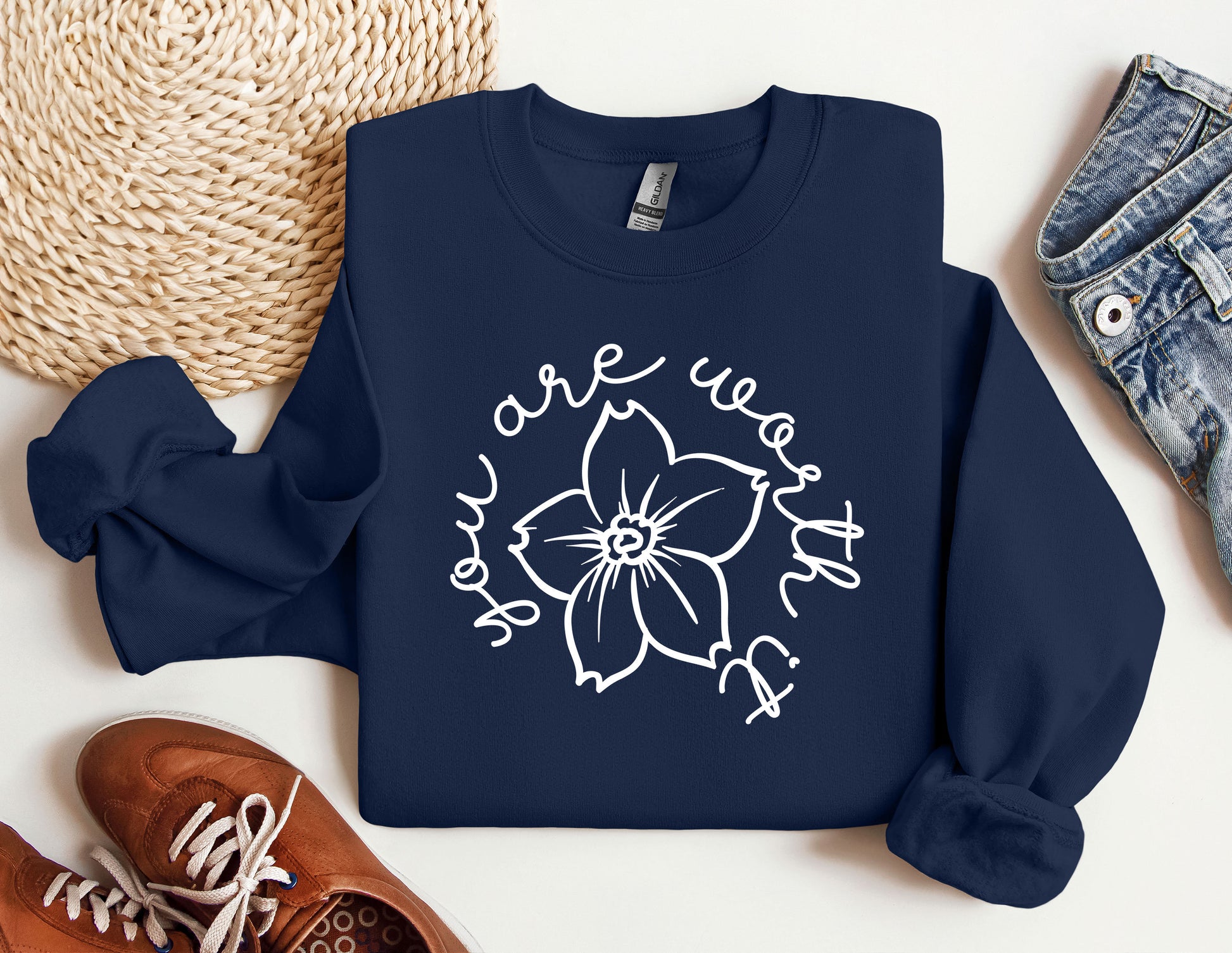 a sweatshirt with a flower on it next to a pair of shoes