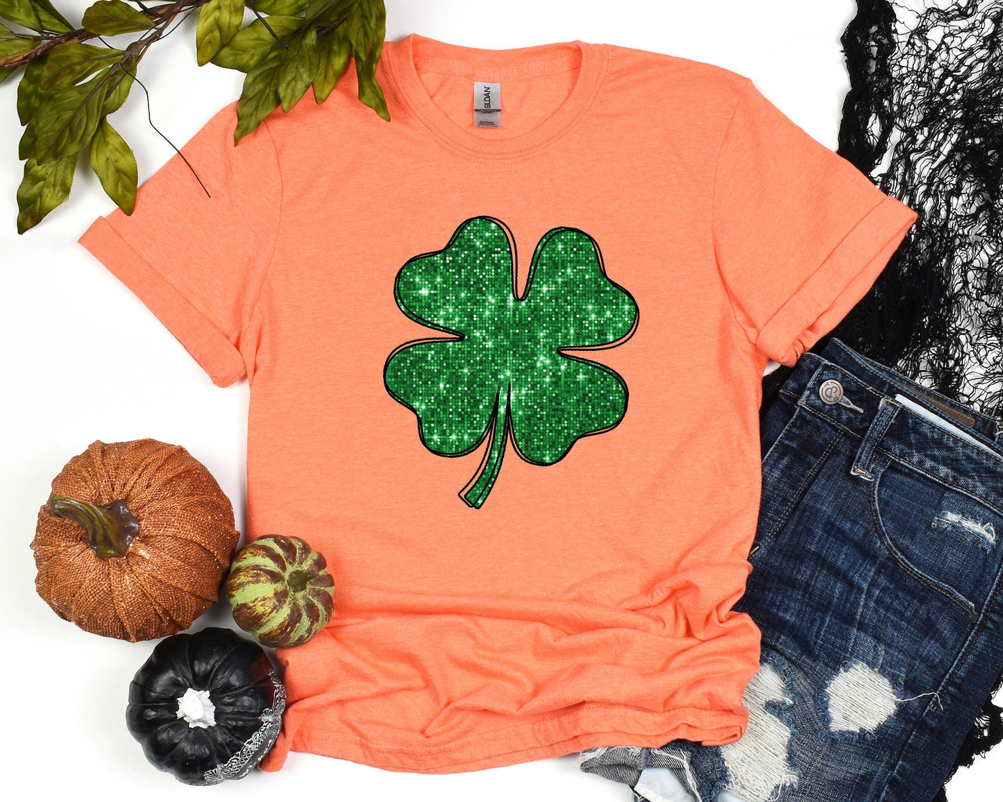 a t - shirt with a shamrock on it next to pumpkins