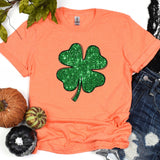 a t - shirt with a shamrock on it next to pumpkins