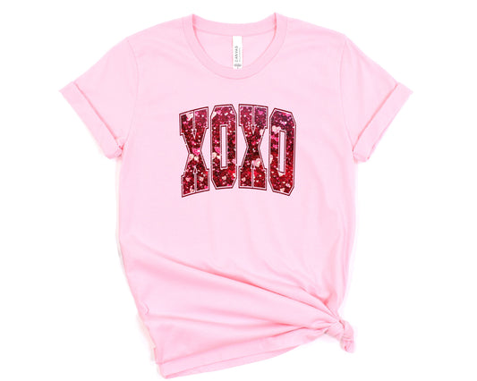 a pink t - shirt with the word okay printed on it