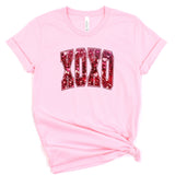 a pink t - shirt with the word okay printed on it