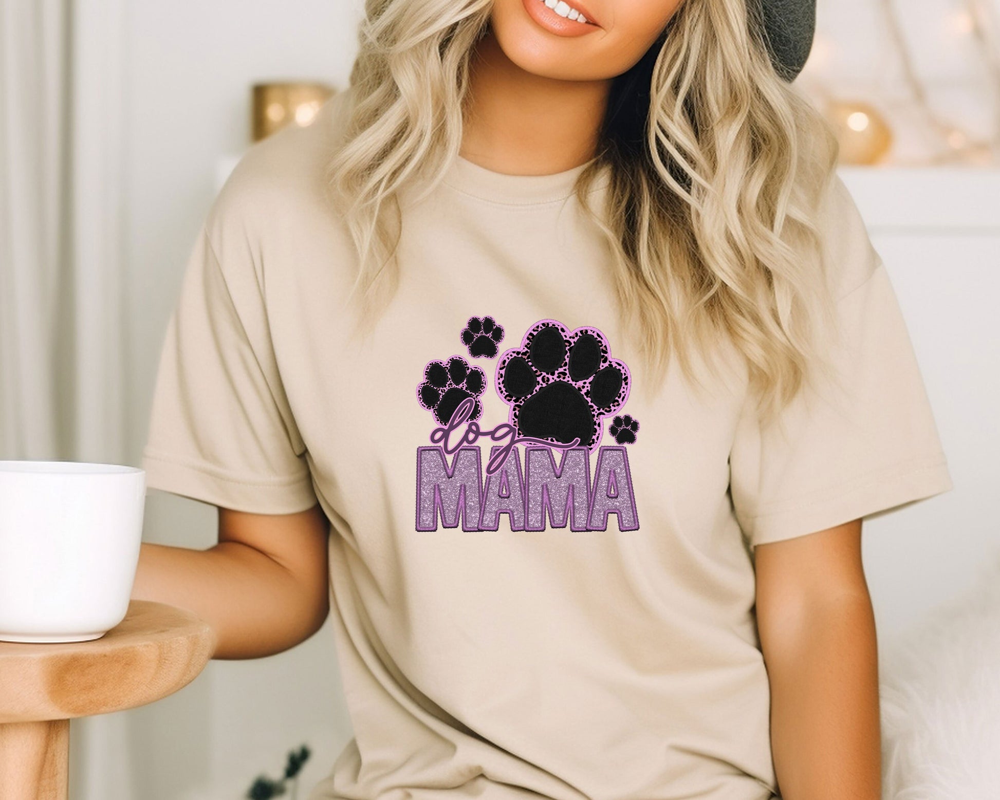 a woman wearing a t - shirt that says mama with paw prints