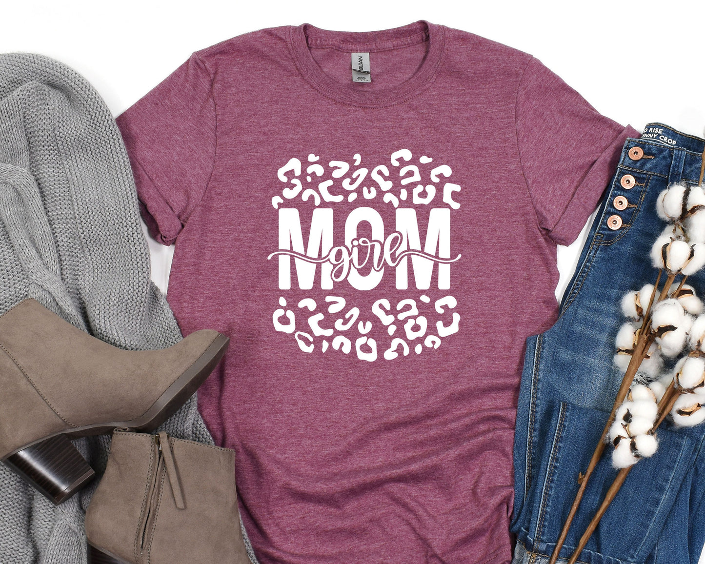 a t - shirt with the words mom on it next to a pair of jeans