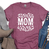 a t - shirt with the words mom on it next to a pair of jeans