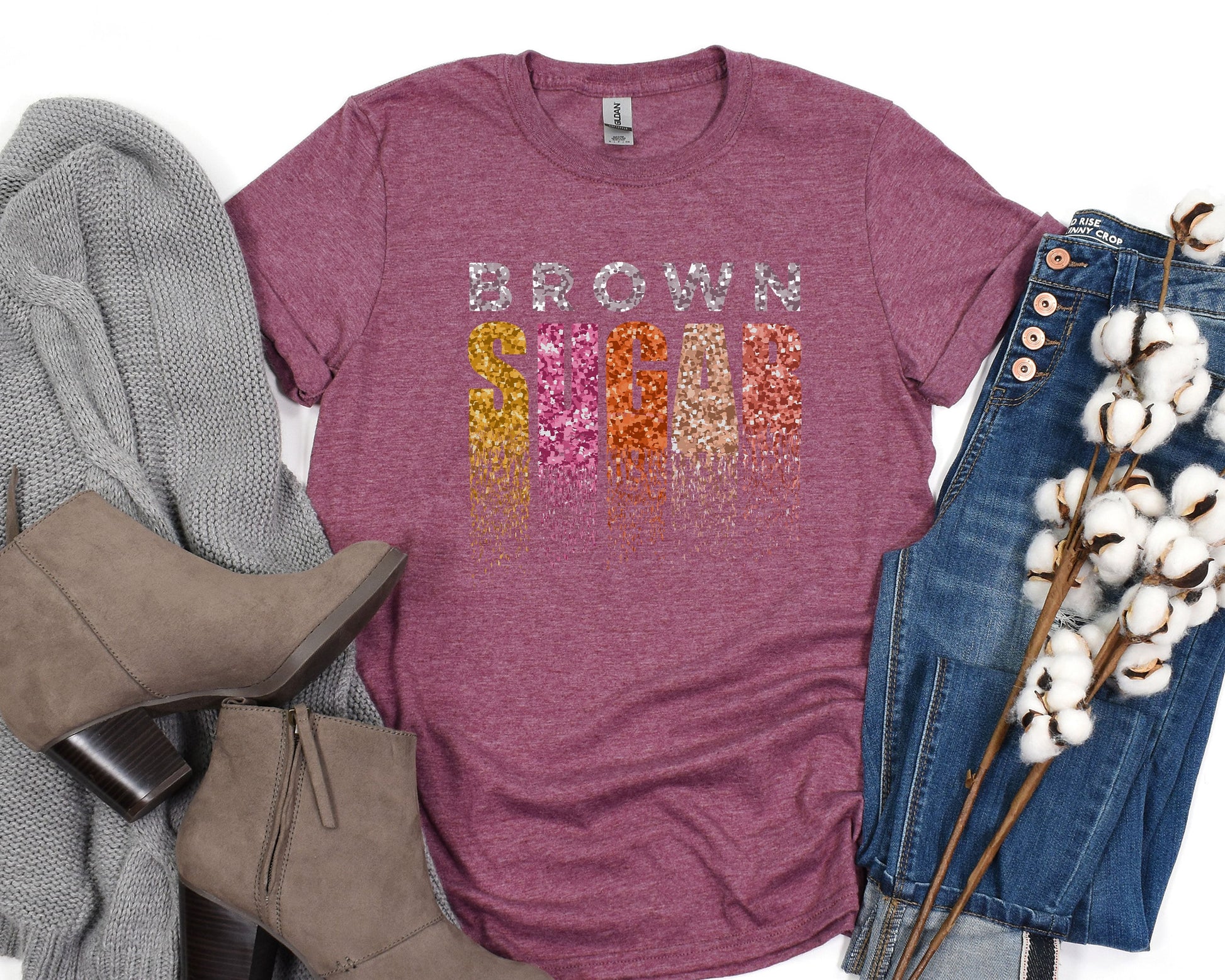 a t - shirt with the words brown on it next to a pair of jeans