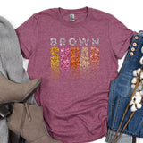 a t - shirt with the words brown on it next to a pair of jeans