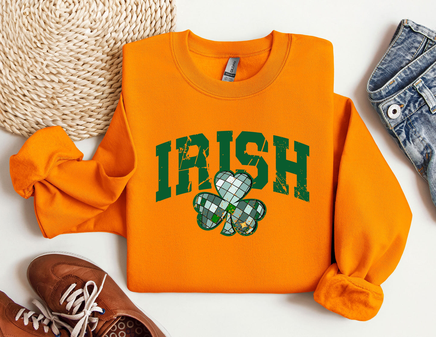 a sweater with a shamrock on it next to a pair of shoes