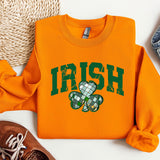 a sweater with a shamrock on it next to a pair of shoes