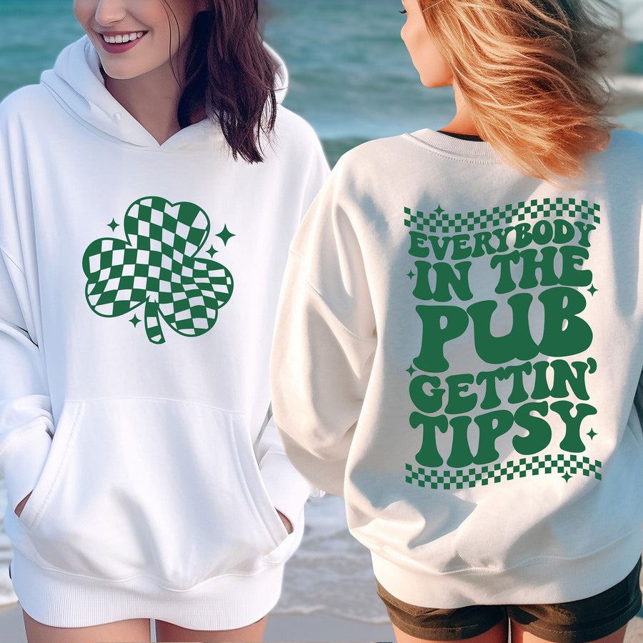 two women wearing st patrick's day sweatshirts on the beach