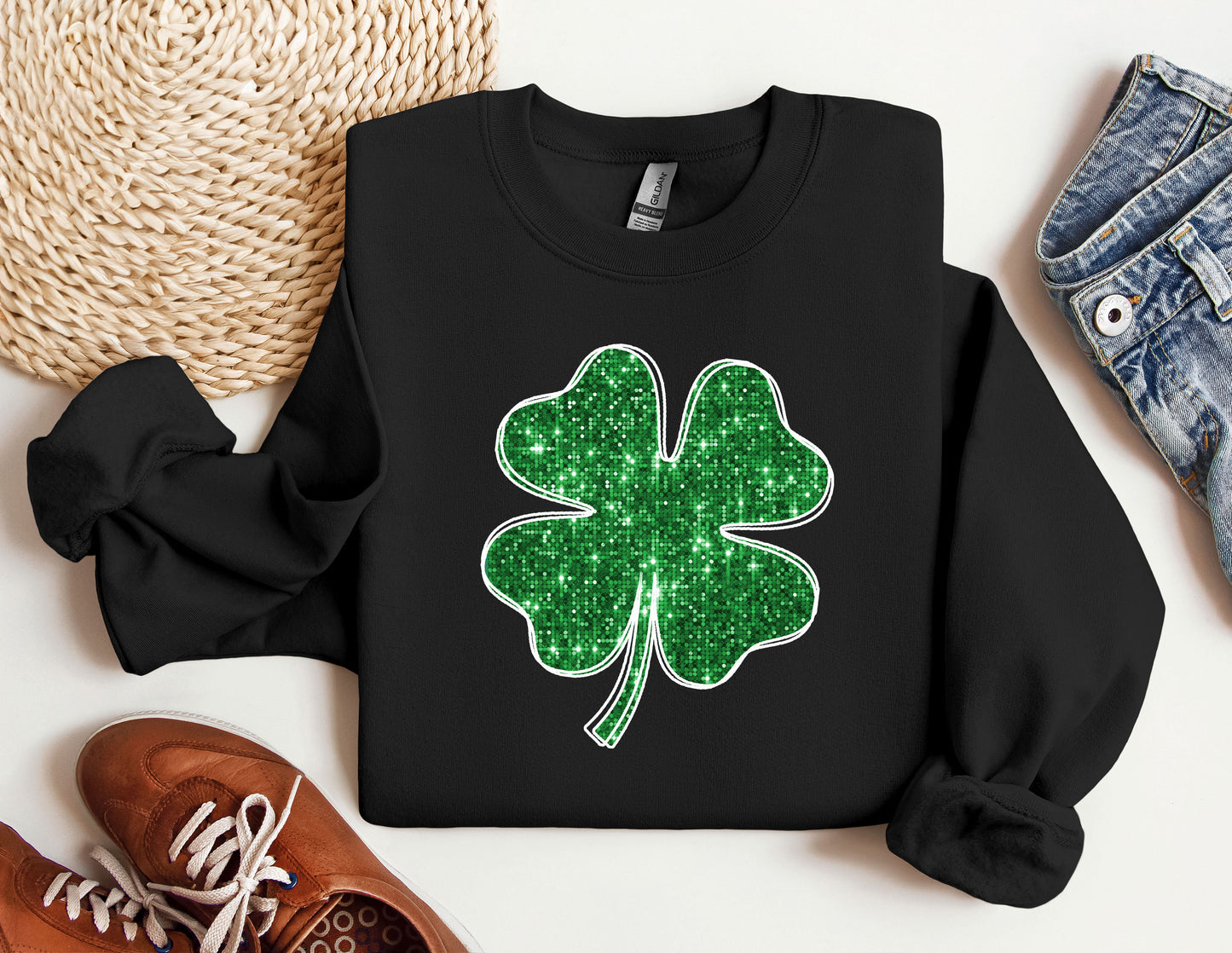 a black sweater with a green shamrock on it