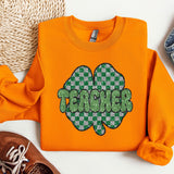 a pair of shoes and an orange shirt with a shamrock on it