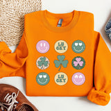 a pair of shoes and an orange shirt with shamrocks on it