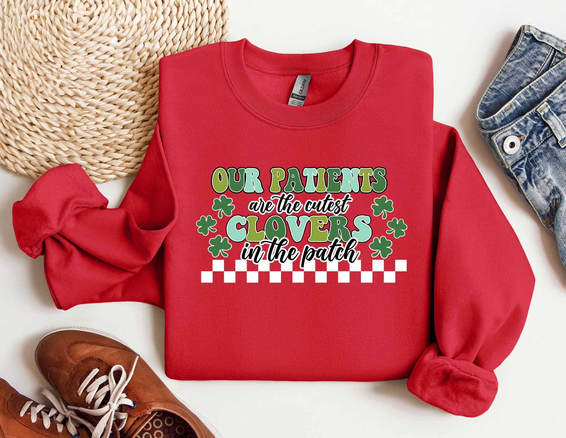 a red sweater with a message on it next to a pair of shoes
