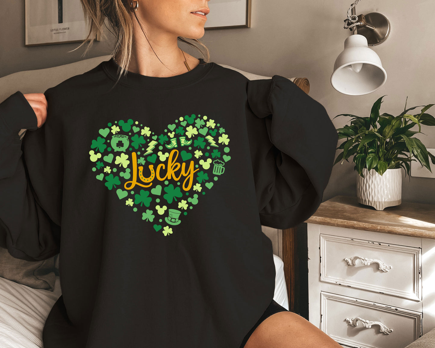 a woman sitting on a bed wearing a black shirt that says lucky