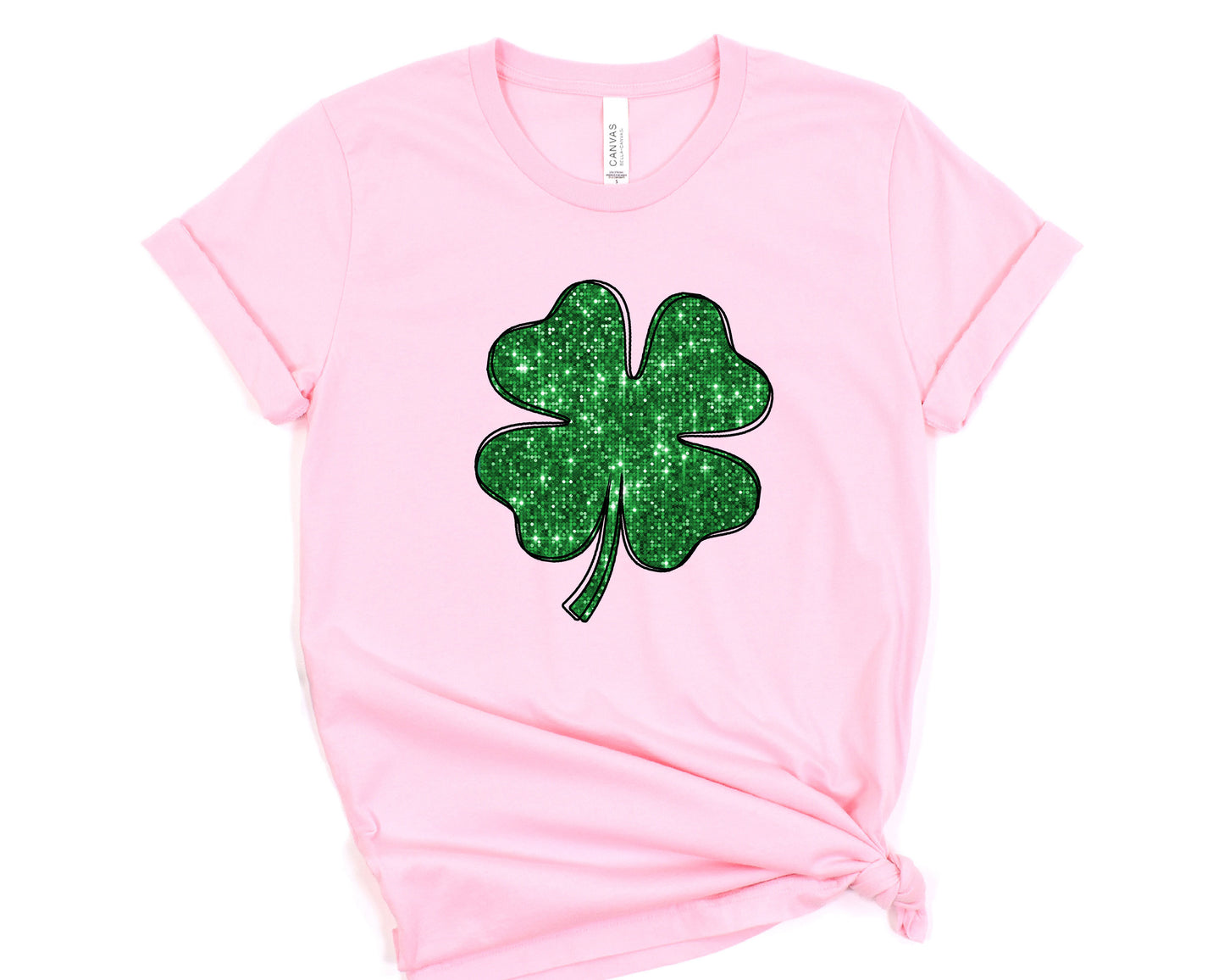 a pink shirt with a green shamrock on it