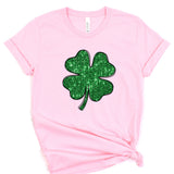 a pink shirt with a green shamrock on it