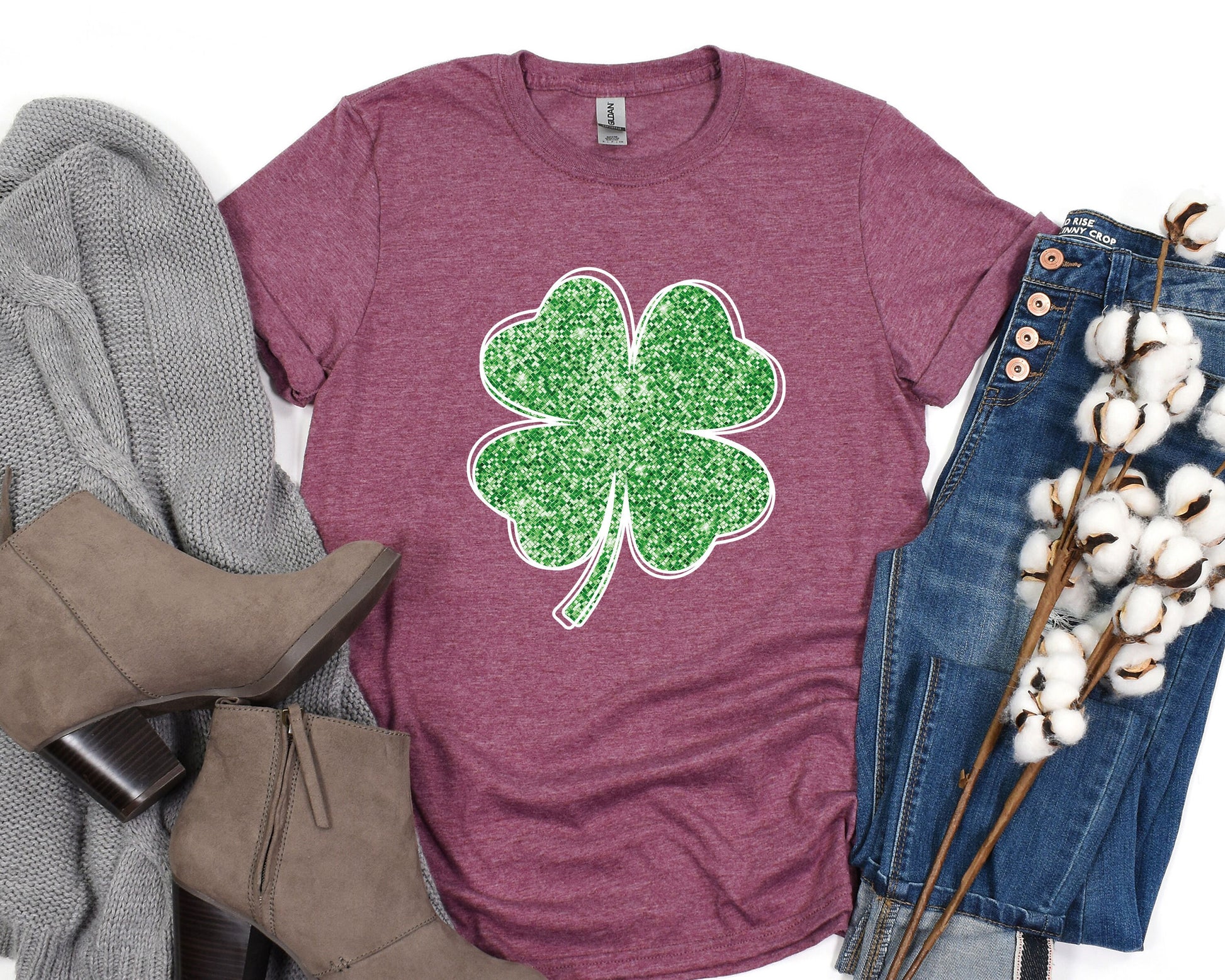 a t - shirt with a shamrock on it next to a pair of jeans