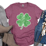 a t - shirt with a shamrock on it next to a pair of jeans